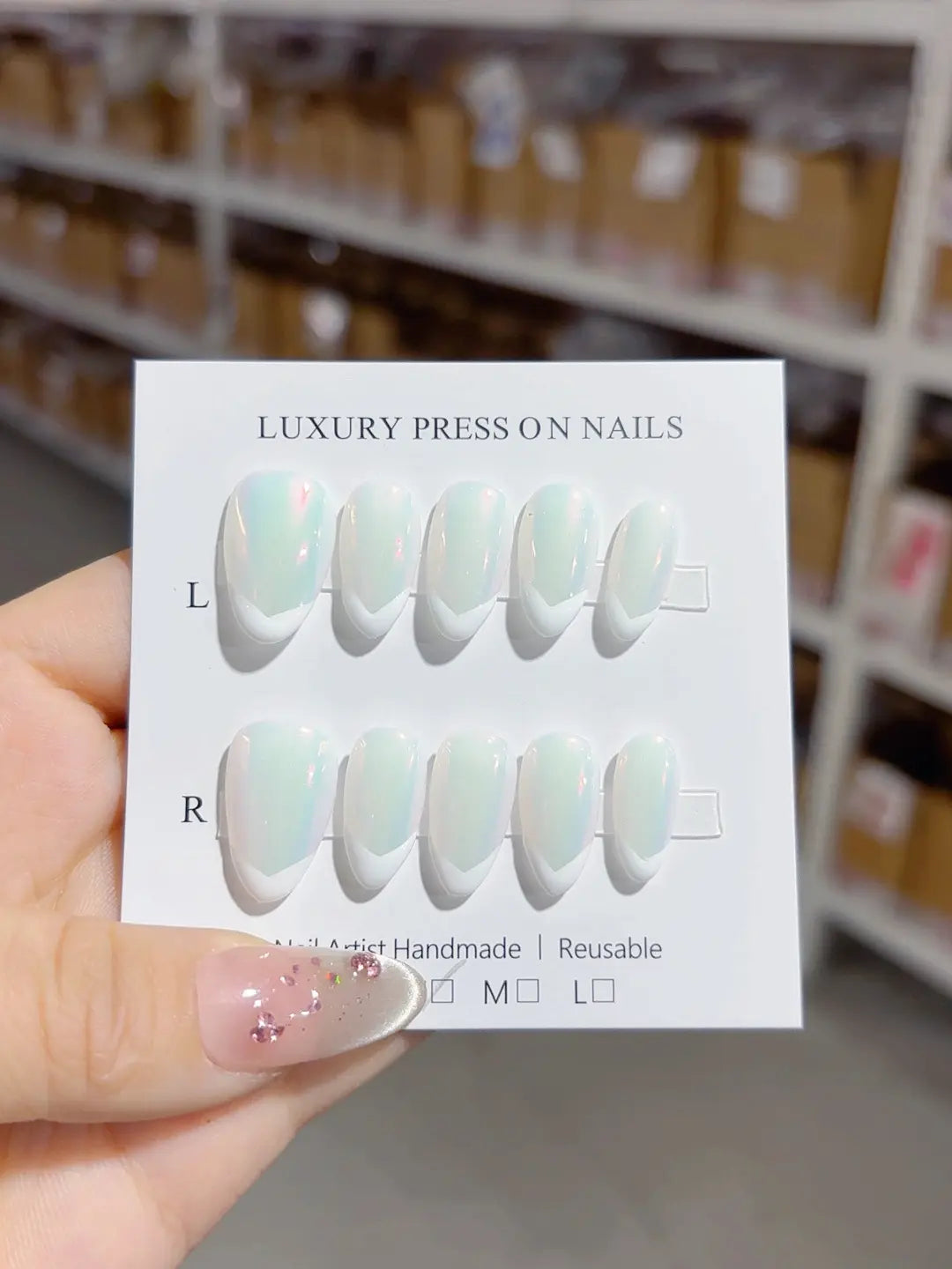 Handmade press on nails almond shape with white V-tip French design, angled close-up