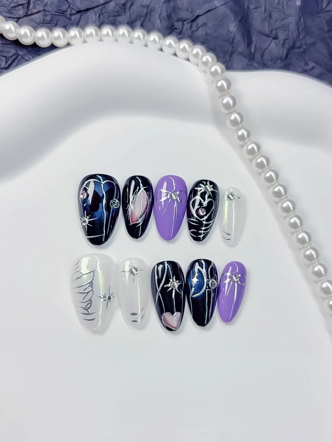 Handmade press on nails short almond purple and black with heart and luxury details close-up