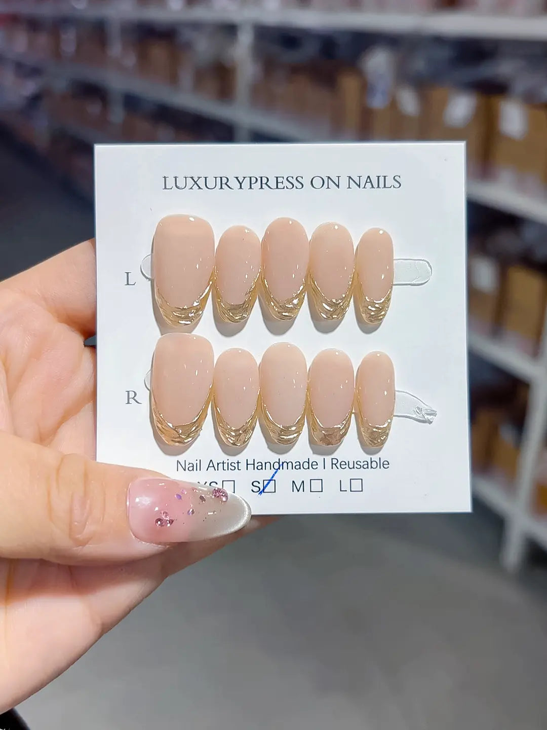 full set display, glossy nude oval with gold french accents, handmade press on nails
