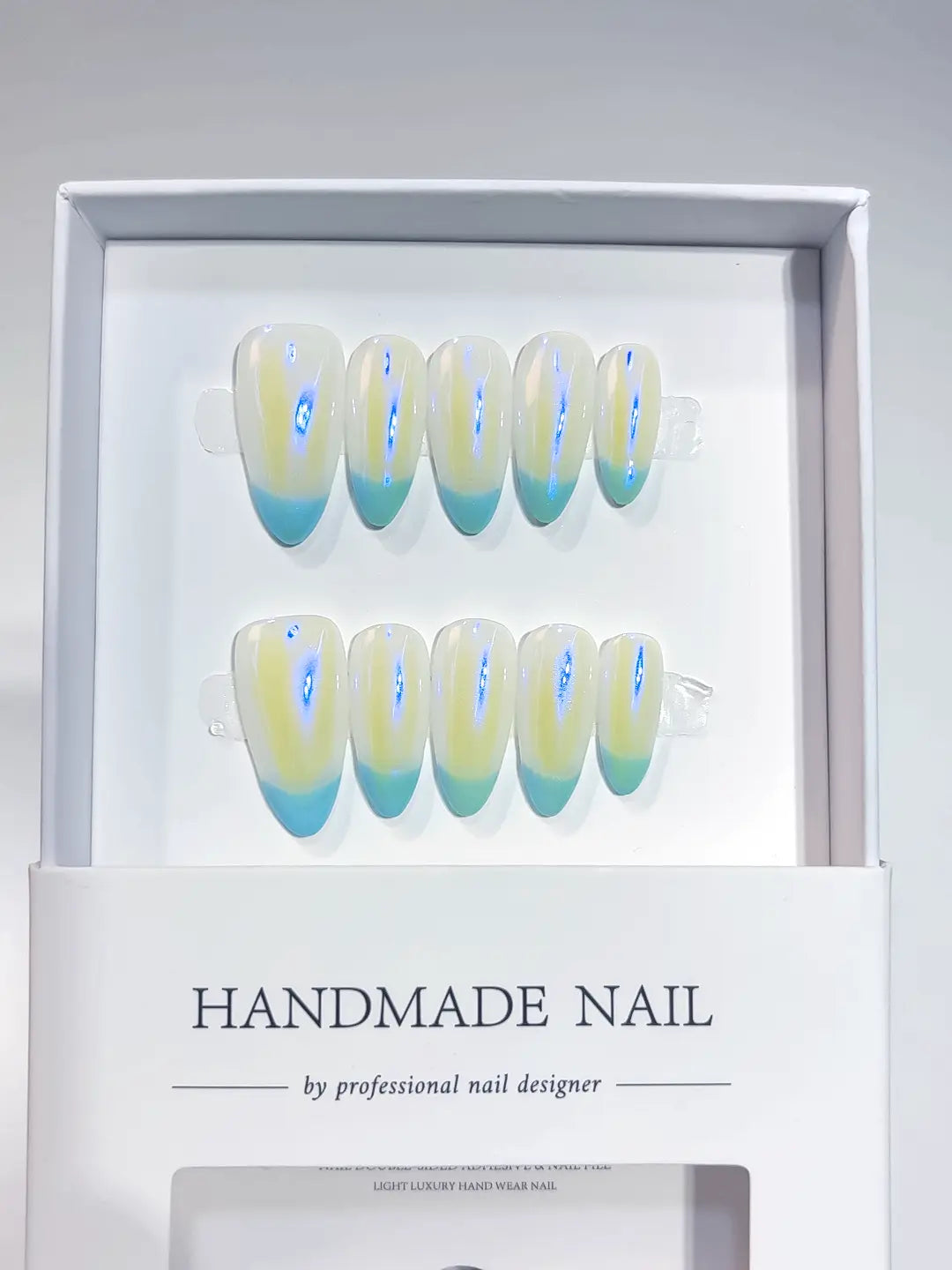 Angled view of iridescent glazed chrome finish on almond aurora handmade press on nails.
