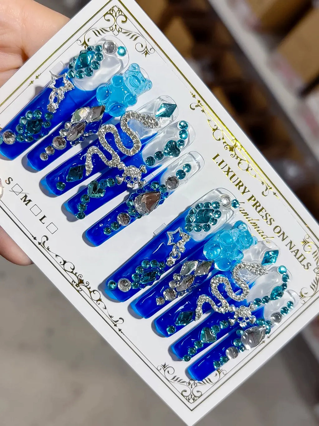 Angled view showing 3D bear charm, silver teardrop gems, and blue tips