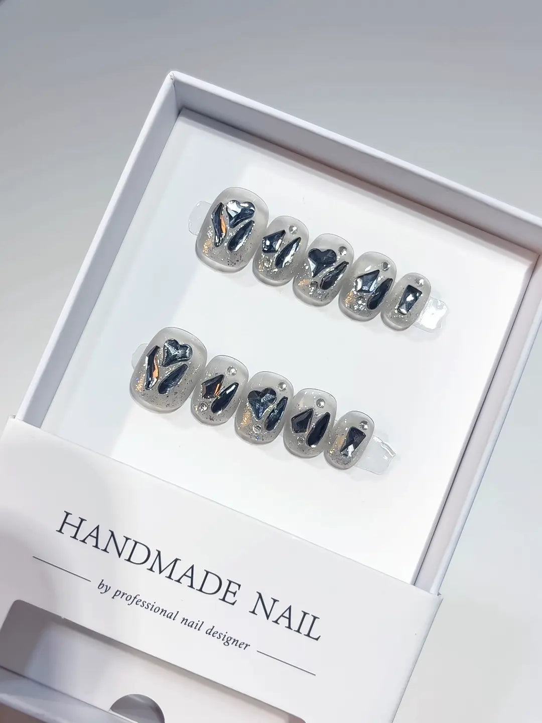 Close-up of sparkle rhinestone handmade press on nails showing the detailed 3D heart and geometric diamond charms.