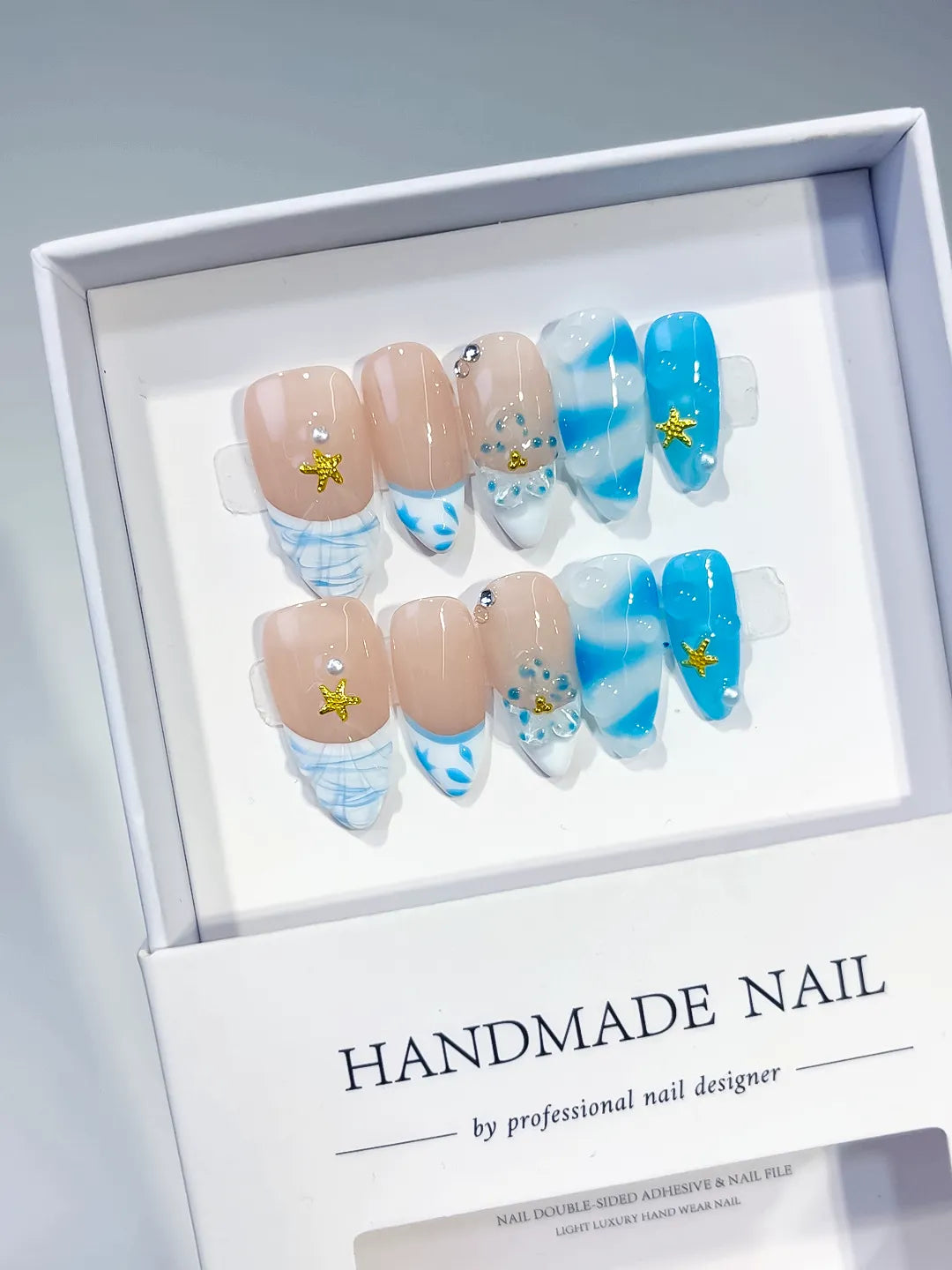 Nude Blue White French tip Star Rhinestone Shell press on nails angled view