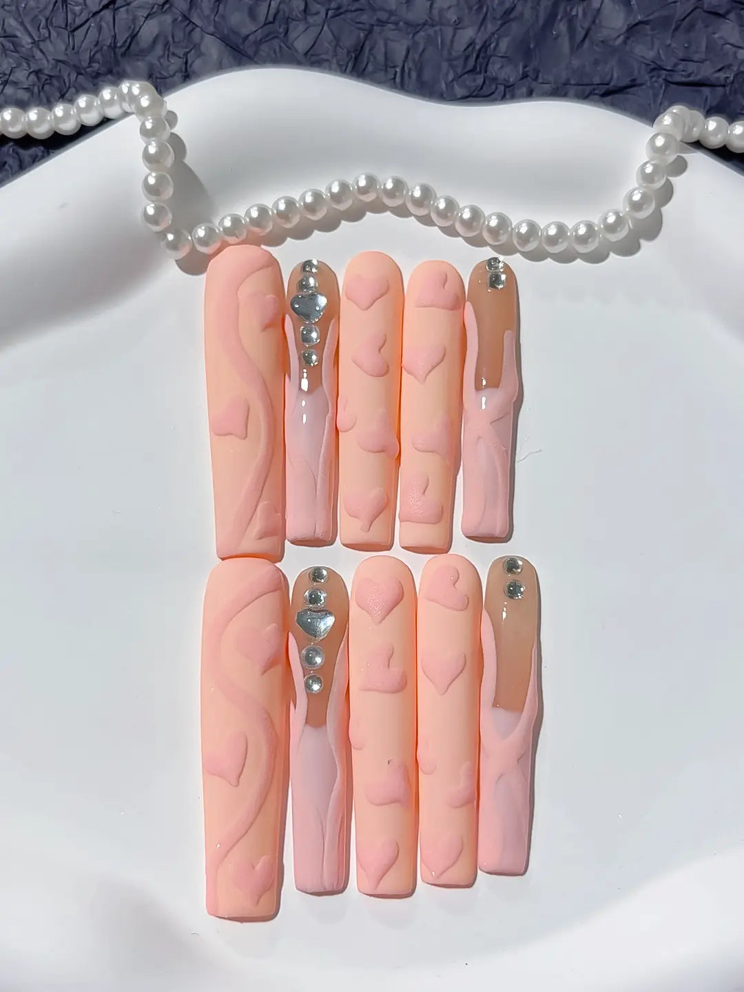 Detailed view of luxury diamond rhinestone accents on long square handmade press on nails.
