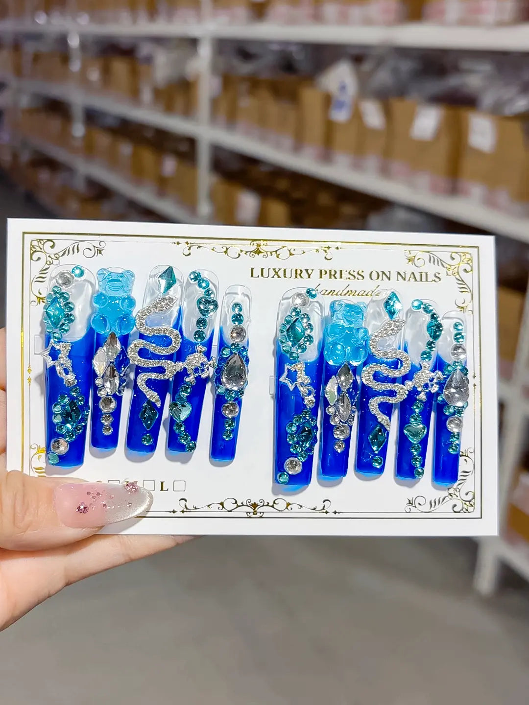 Full set layout: long square blue nails with clear sections, rhinestone arcs and snake charm
