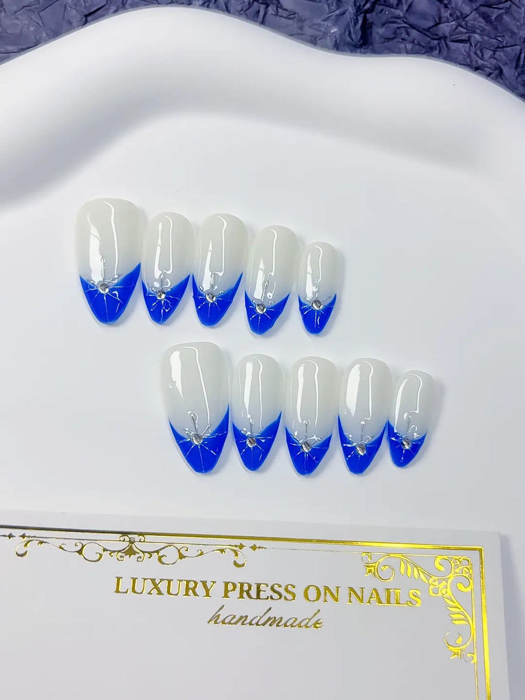 Full set layout: medium almond blue-and-white French with centered rhinestone stars