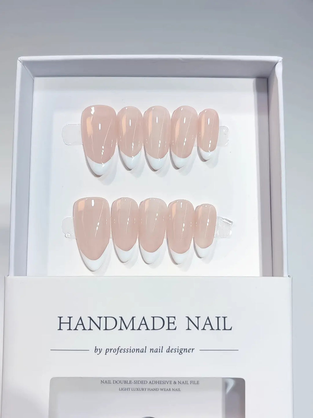 Full set of 10 medium almond handmade press on nails featuring classic pink and white solid french tips.
