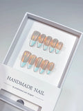 Full set of luxury blue aurora French handmade press on nails showing the iridescent chrome effect.
