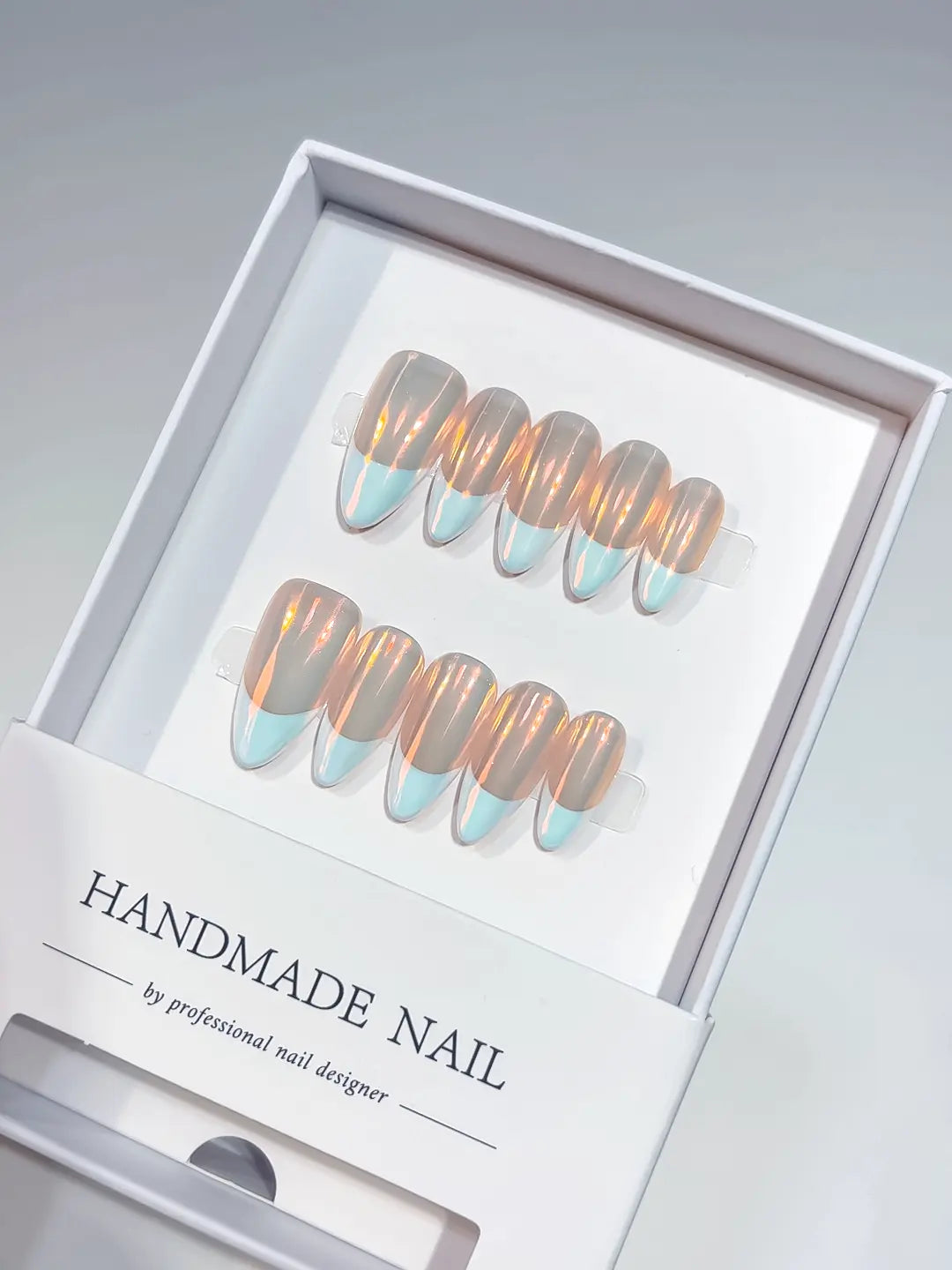 Full set of luxury blue aurora French handmade press on nails showing the iridescent chrome effect.
