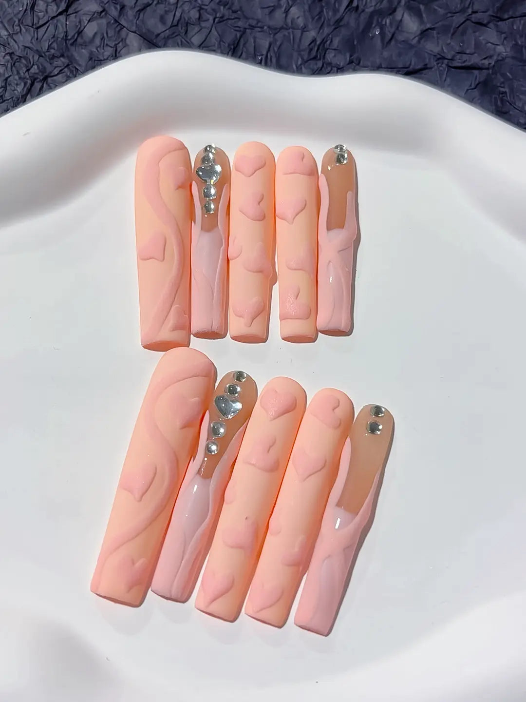 Full set presentation of nude and pink 3D heart handmade press on nails for a sweet look.
