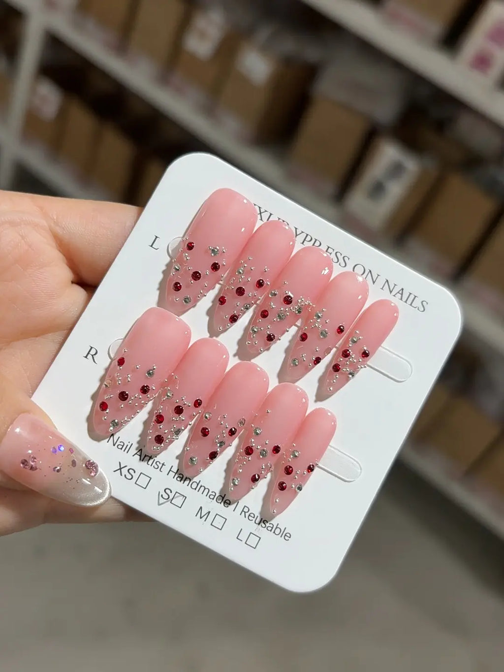 Handmade press on nails almond shape pink with silver and red gems angled shot