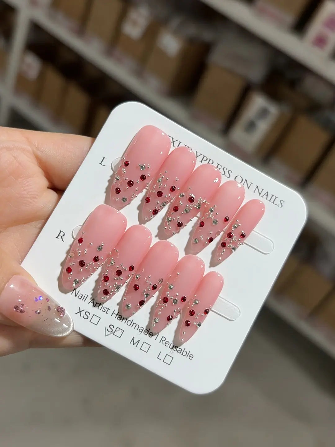 Handmade press on nails almond shape pink with silver and red gems angled shot