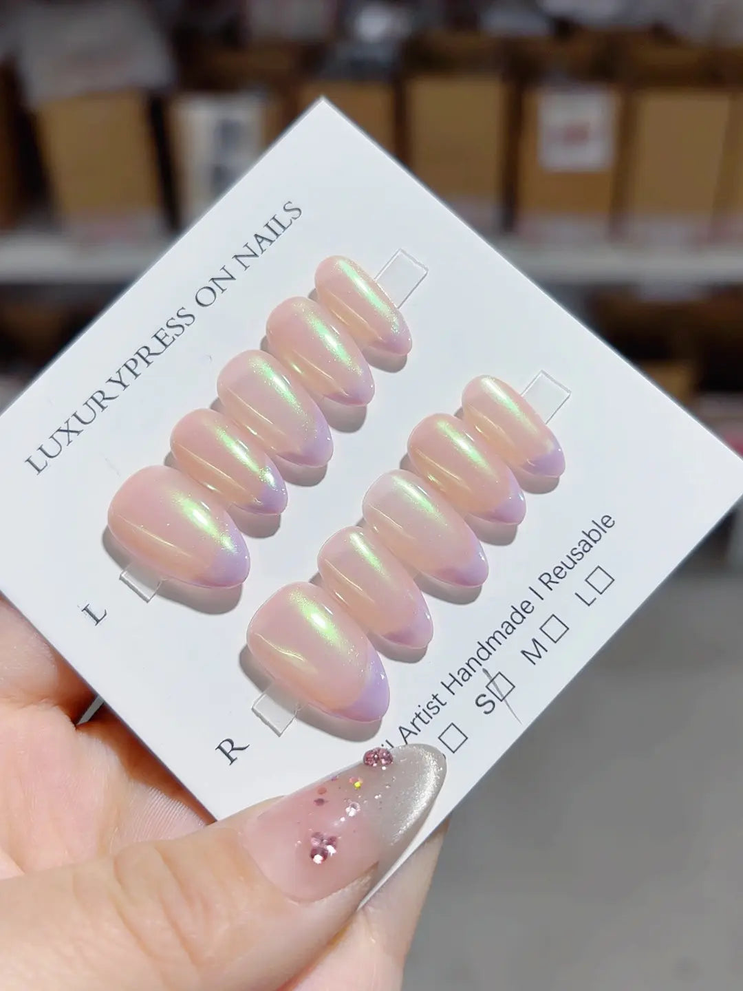 Handmade press on nails nude almond with green-purple aurora overlay, angled close-up