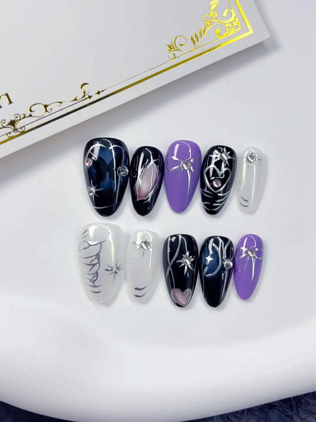 Handmade press on nails short almond black white silver with spider and bow angled view