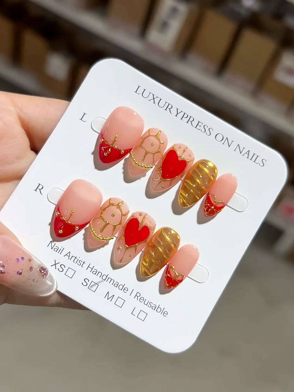 Handmade press on nails short almond nude gold stripe design with luxury finish angled view