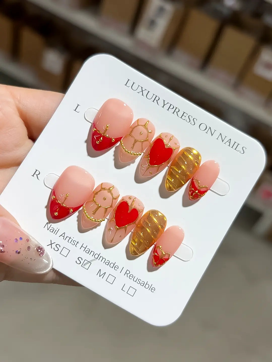 Handmade press on nails short almond nude gold stripe design with luxury finish angled view