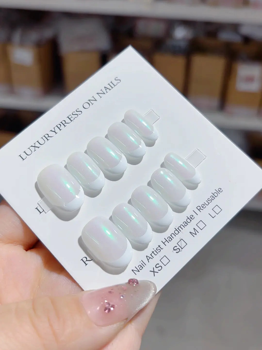 Handmade press on nails short oval white with green aurora shine, angled display