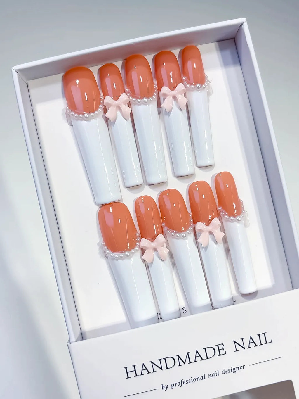 Orange White Pink French tip Bow Pearl 3D press on nails angled view