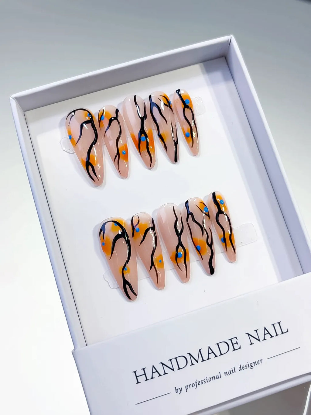 Nude Orange Black Blue Abstract Dot Pattern press on nails angled view