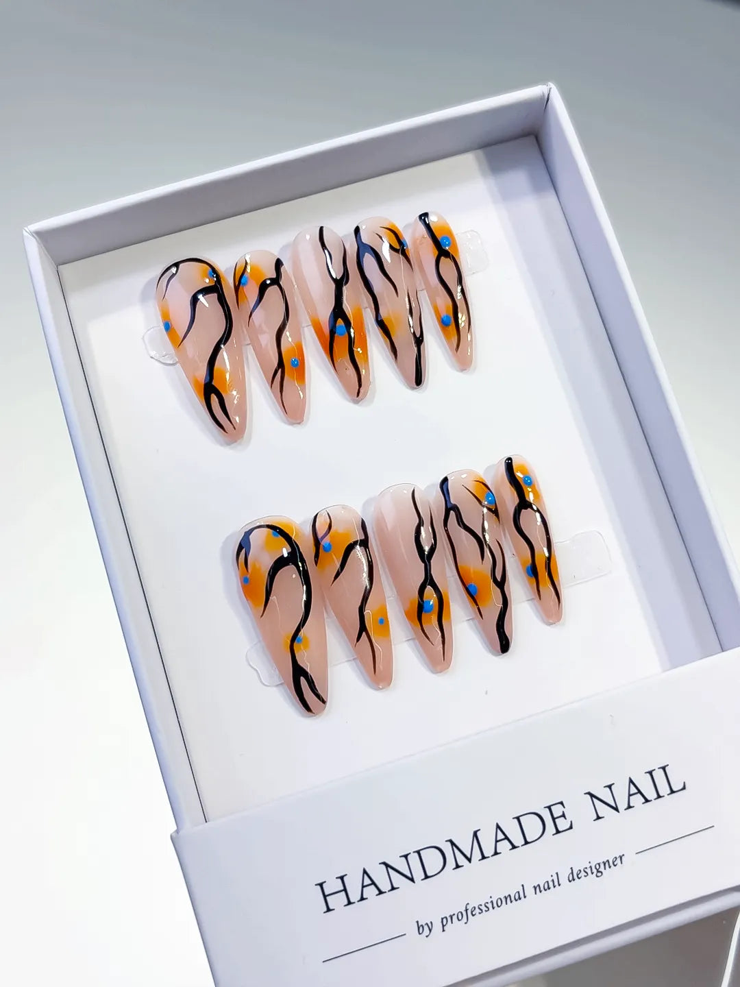 Nude Orange Black Blue Abstract Dot Pattern press on nails angled view