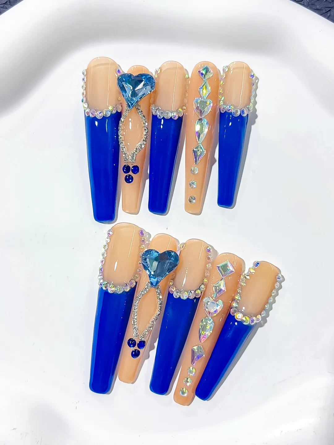 Long coffin set with nude base, bold blue French tips and a large 3D rhinestone heart centerpiece handmade press on nails