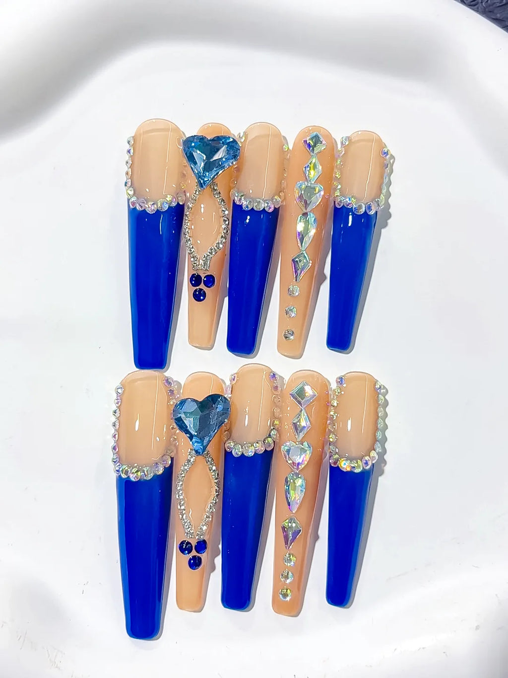 Long coffin set with nude base, bold blue French tips and a large 3D rhinestone heart centerpiece handmade press on nails