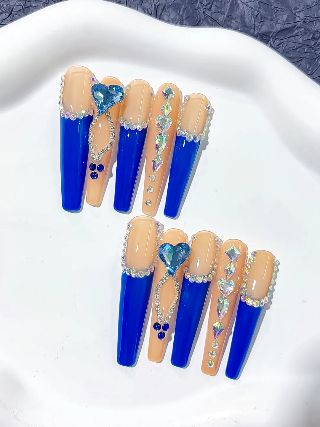 Long coffin set with nude base, bold blue French tips and a large 3D rhinestone heart centerpiece handmade press on nails
