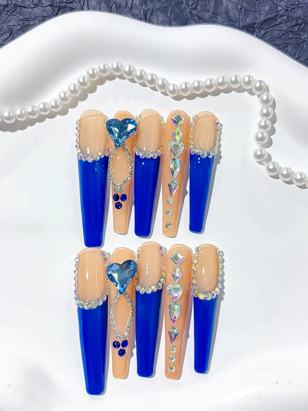 Long coffin set with nude base, bold blue French tips and a large 3D rhinestone heart centerpiece handmade press on nails