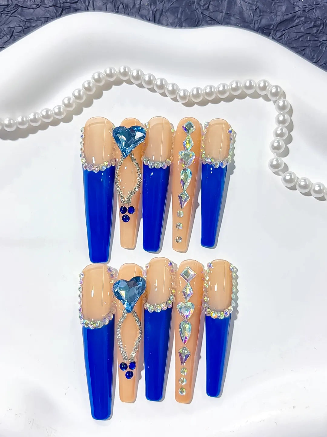 Long coffin set with nude base, bold blue French tips and a large 3D rhinestone heart centerpiece handmade press on nails