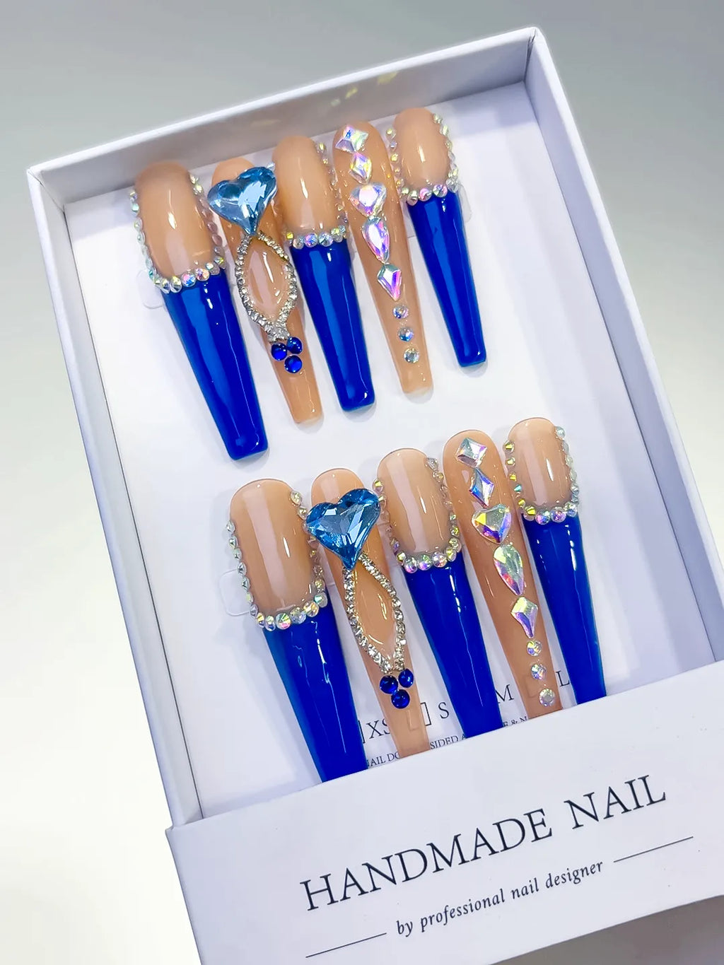 Long coffin set with nude base, bold blue French tips and a large 3D rhinestone heart centerpiece handmade press on nails