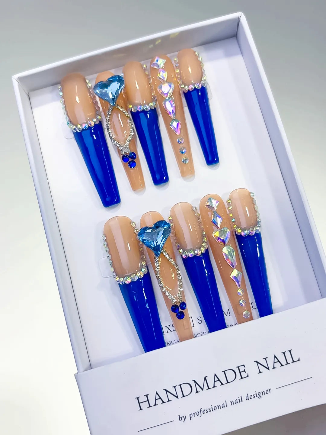 Long coffin set with nude base, bold blue French tips and a large 3D rhinestone heart centerpiece handmade press on nails