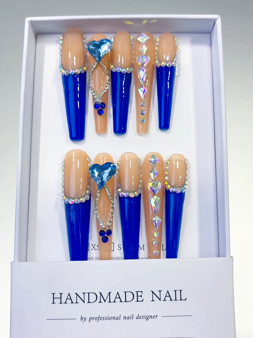 Long coffin set with nude base, bold blue French tips and a large 3D rhinestone heart centerpiece handmade press on nails