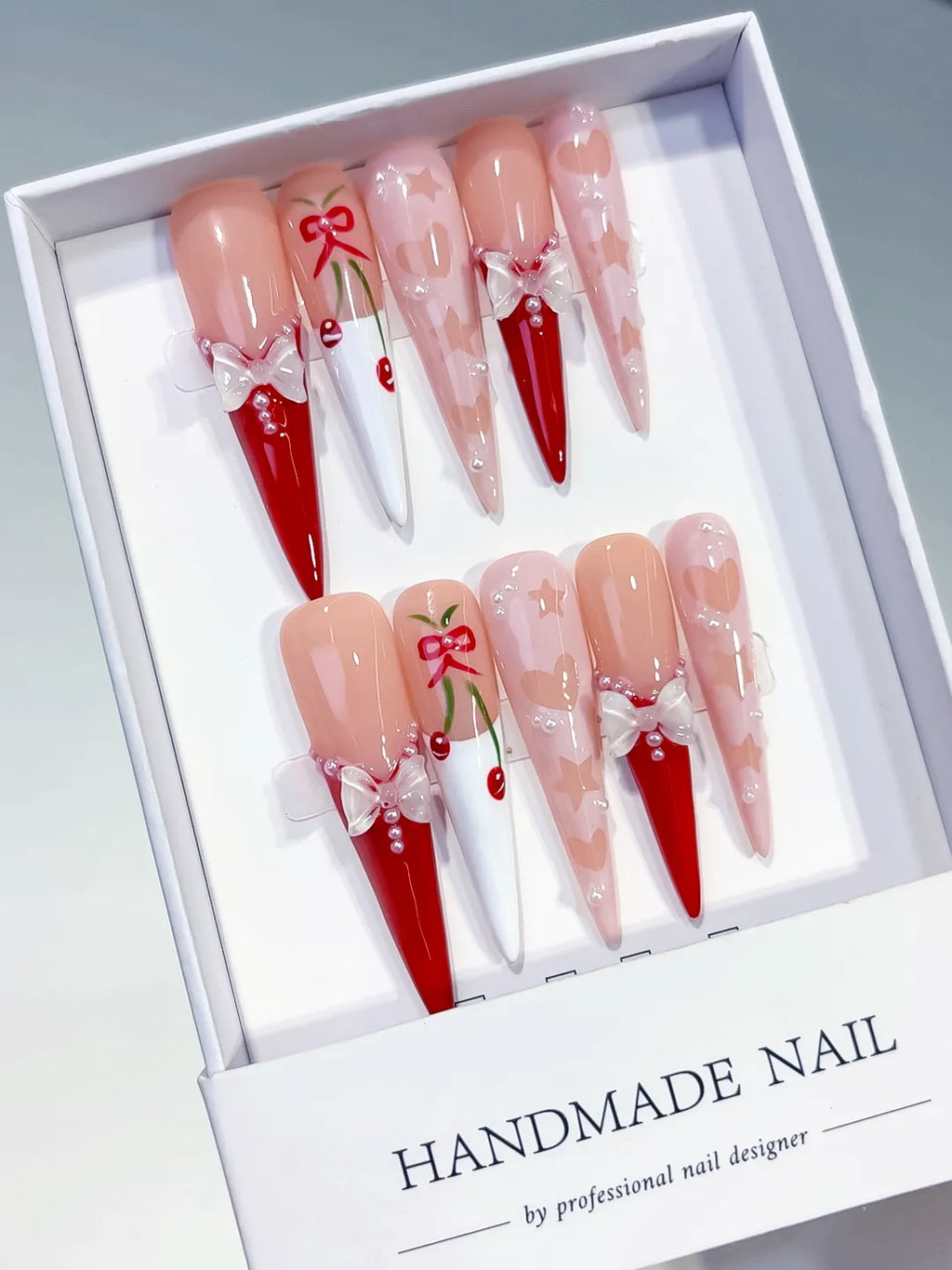 Nude Red White Pink Abstract Cherry Bow press on nails angled view