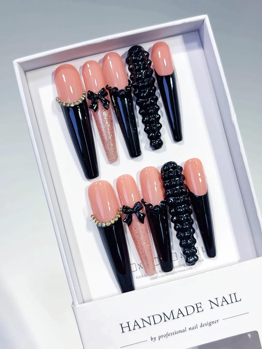 Nude Black Pink Gold French tip Bow Glitter 3D press on nails angled view