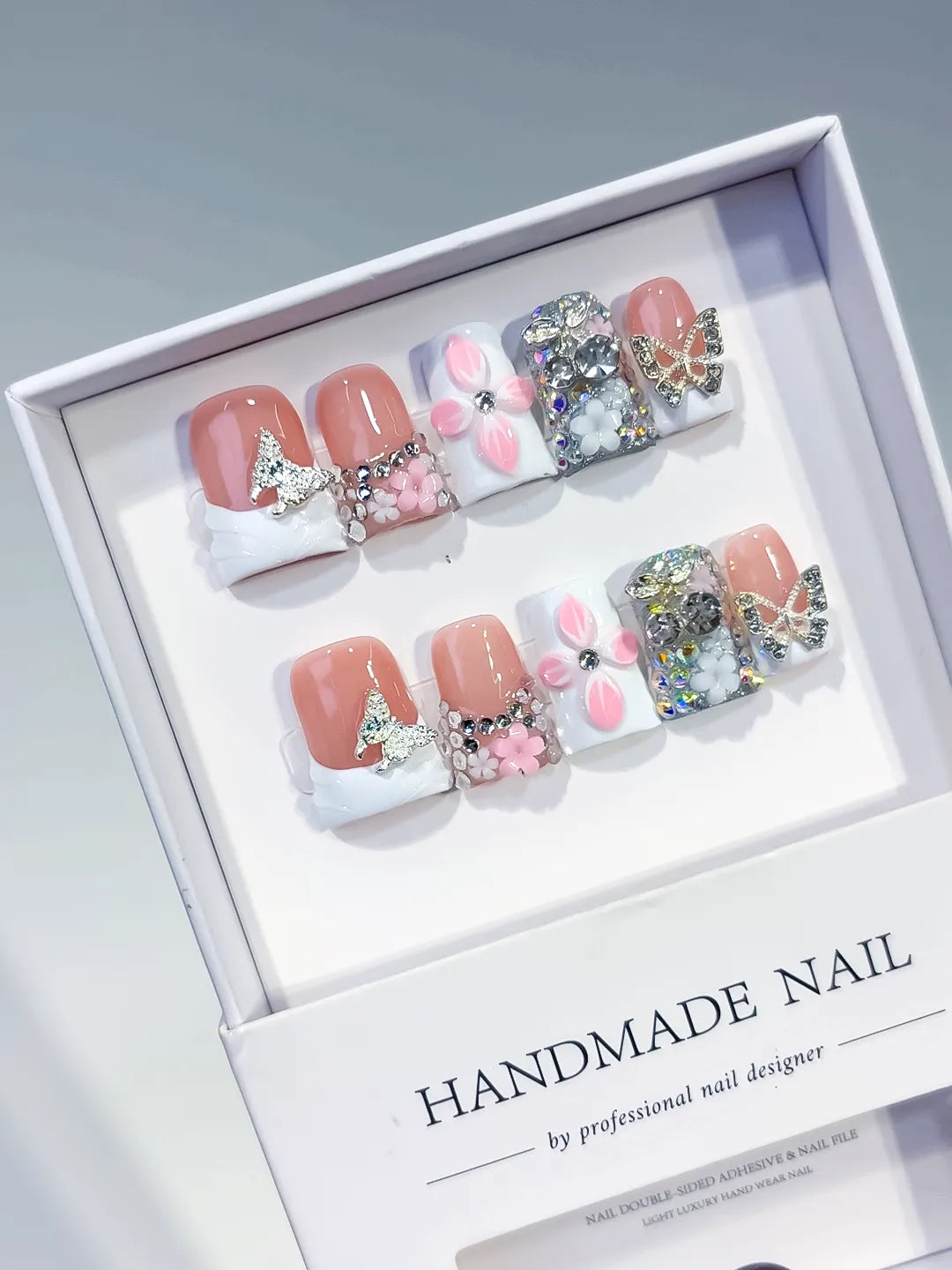 Nude White Pink Silver French tip Butterfly Flower Rhinestone 3D press on nails angled view