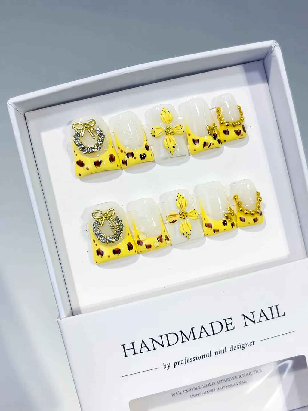 Yellow White Gold Black French tip Bow Heart Rhinestone press on nails angled view
