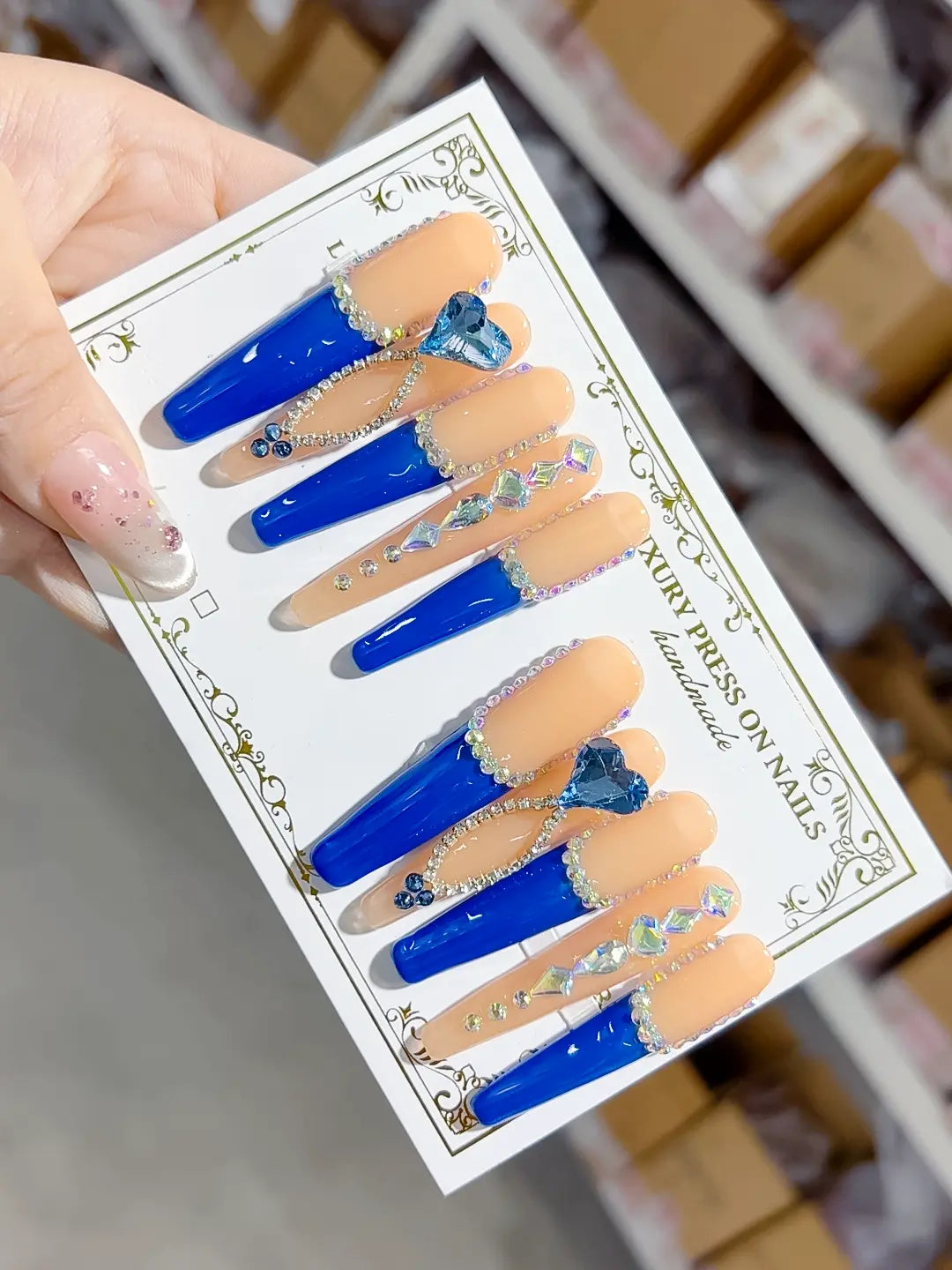 Long coffin set with nude base, bold blue French tips and a large 3D rhinestone heart centerpiece