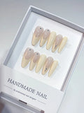 Long oval nude French handmade press on nails with tiny rhinestone details in a white box.
