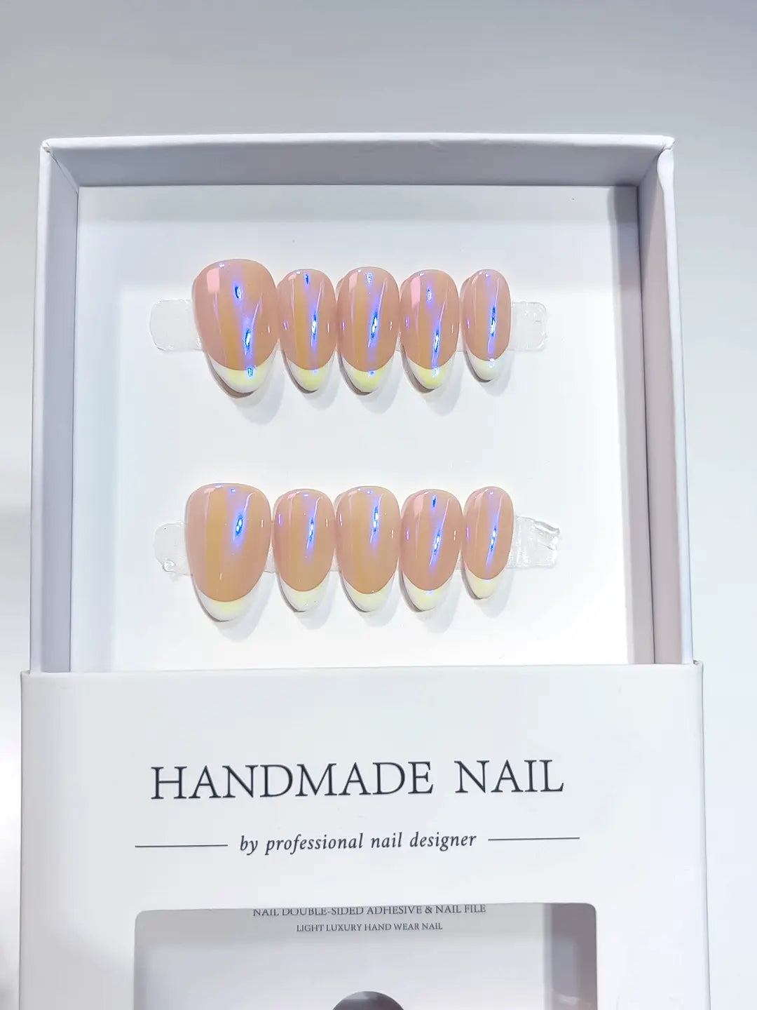 Short almond purple aurora handmade press on nails with iridescent French tips in a display box.