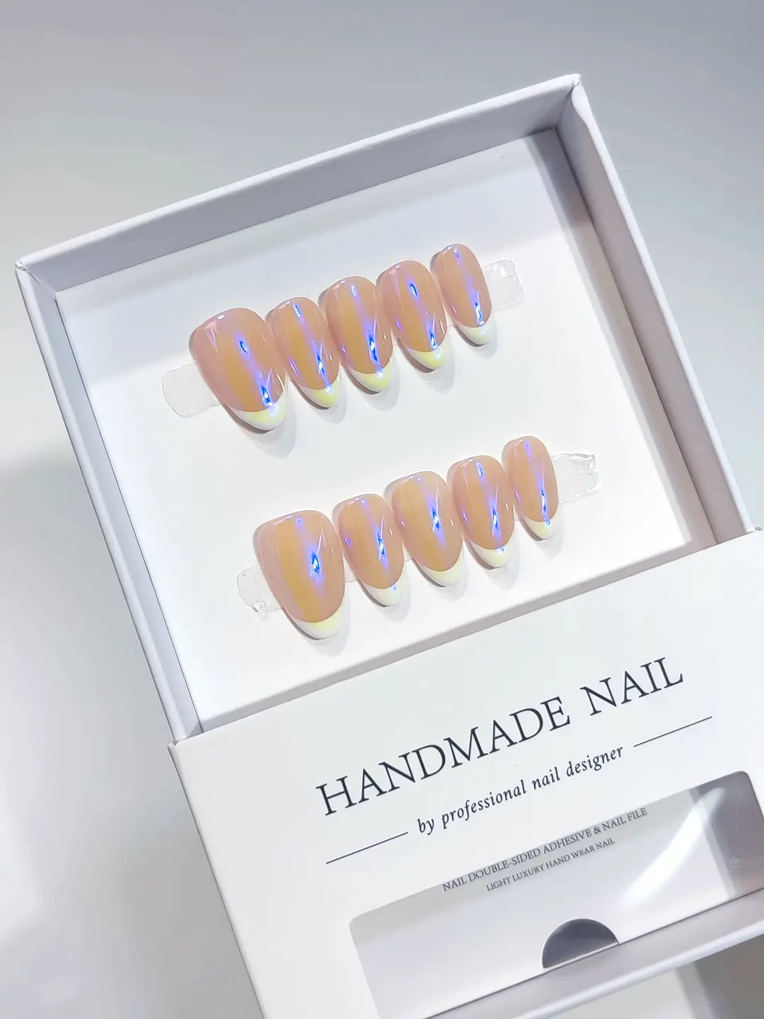 Top view of a full set of purple aurora French handmade press on nails with a natural nude base.