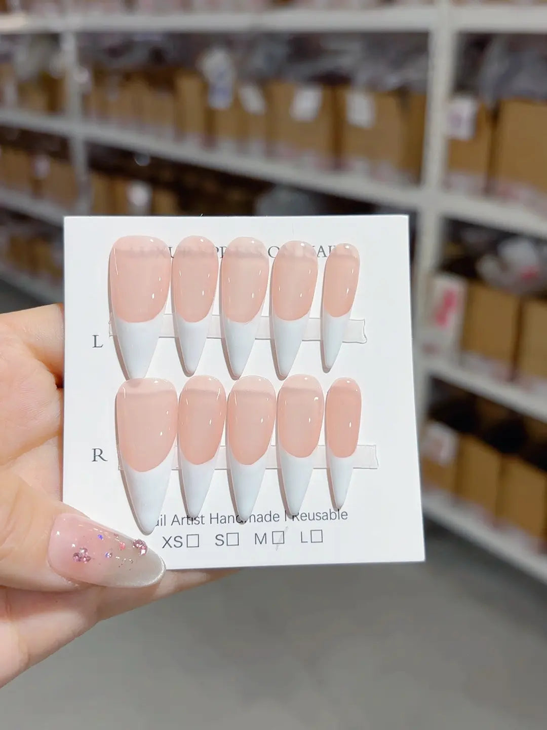 angled view of handmade press on nails, long stiletto French pink white