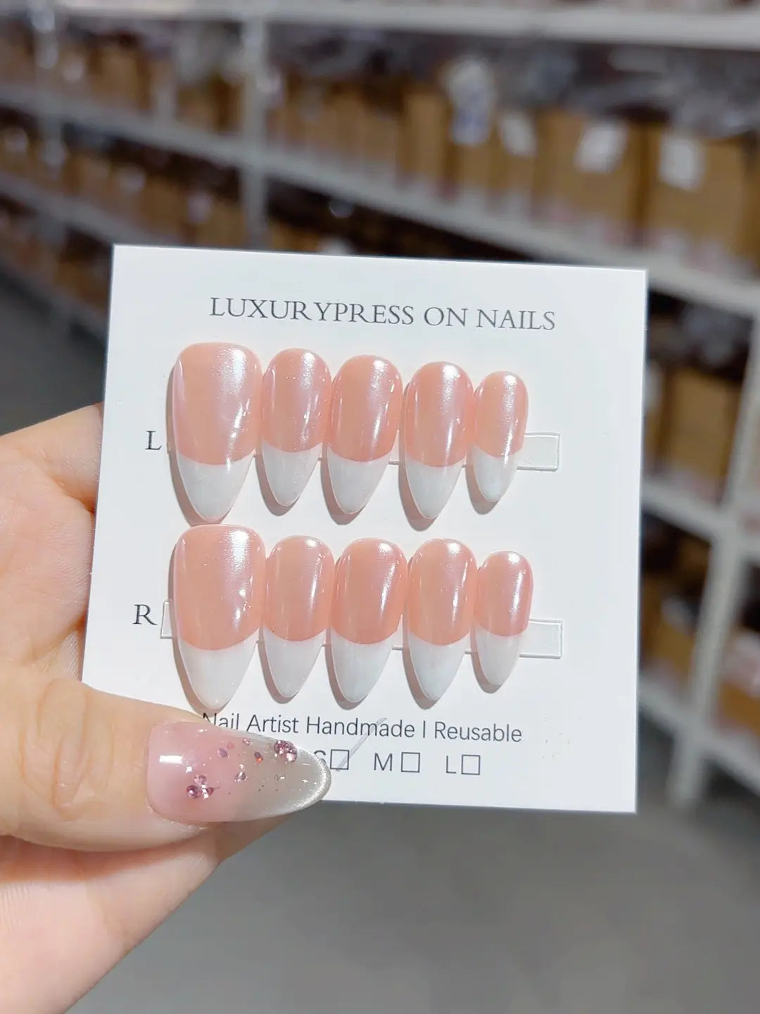angled view of handmade press on nails, medium almond glossy French tips