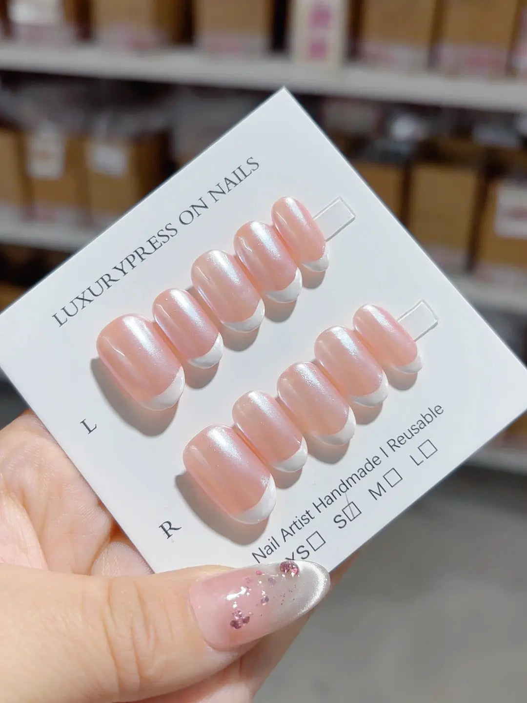 angled view of handmade press on nails, short oval glossy French design
