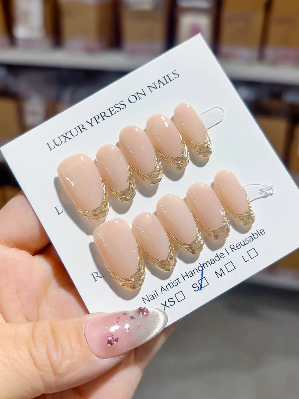 angled view showing metallic gold tips on nude base, handmade press on nails