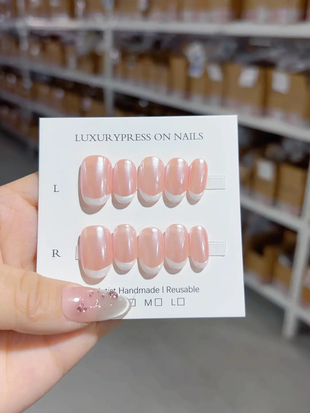 closeup of handmade press on nails, short oval glossy pink white tips