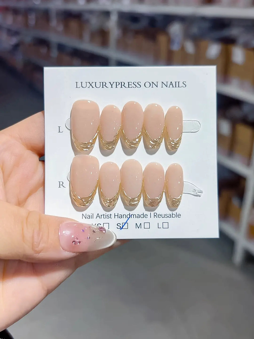 full set display, glossy nude oval with gold french accents, handmade press on nails