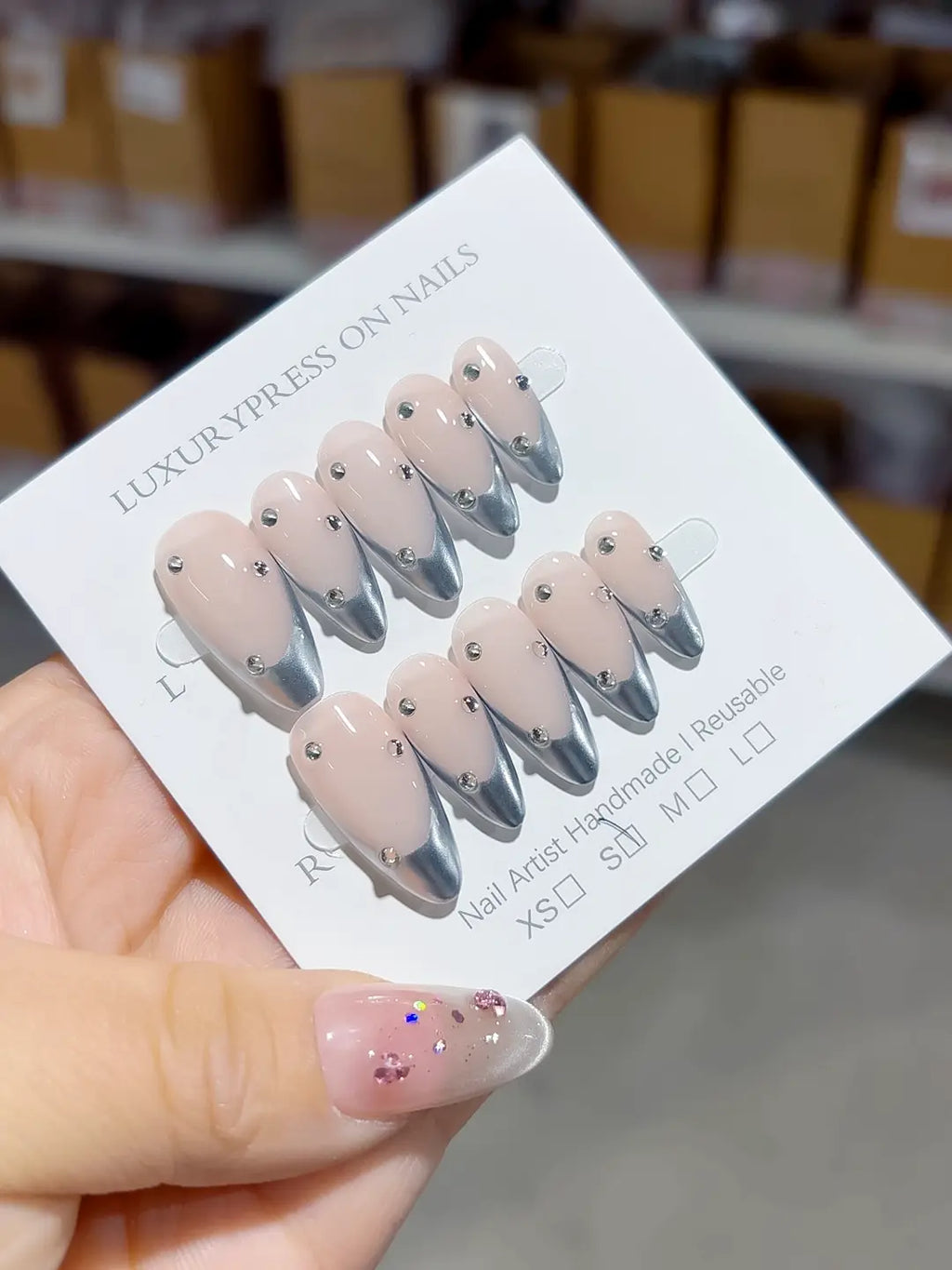 handmade press on nails, full set showing almond shape, chrome tips, and glossy nude finish