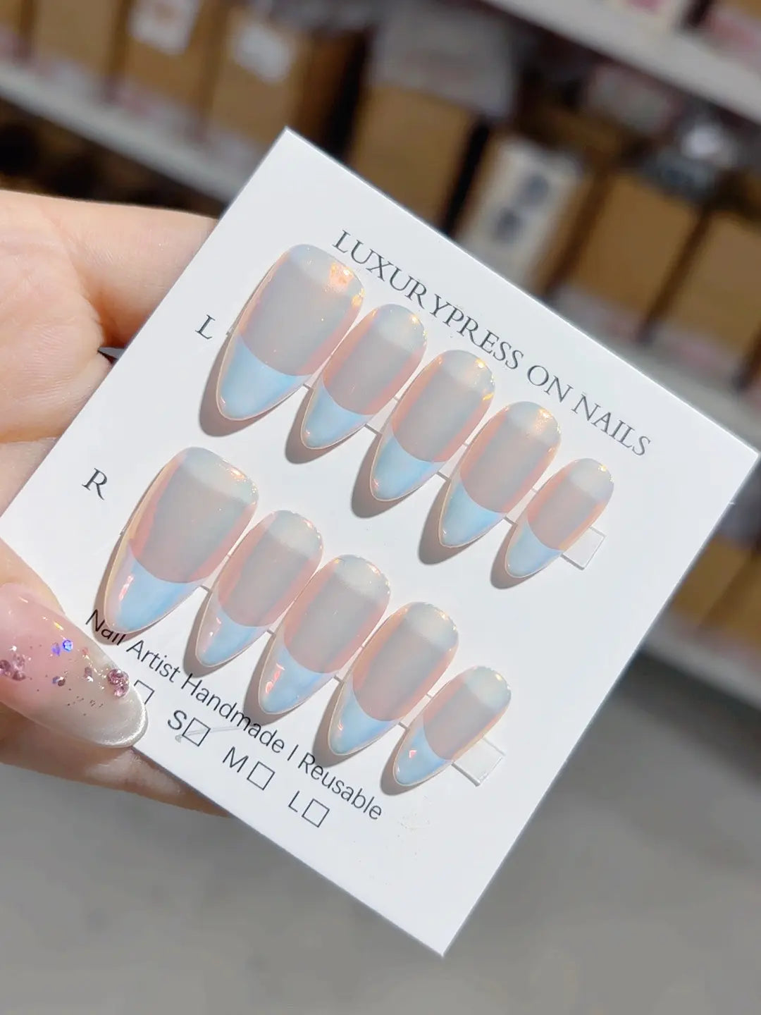 handmade press on nails medium almond close-up with glowing clear body and blue French detail