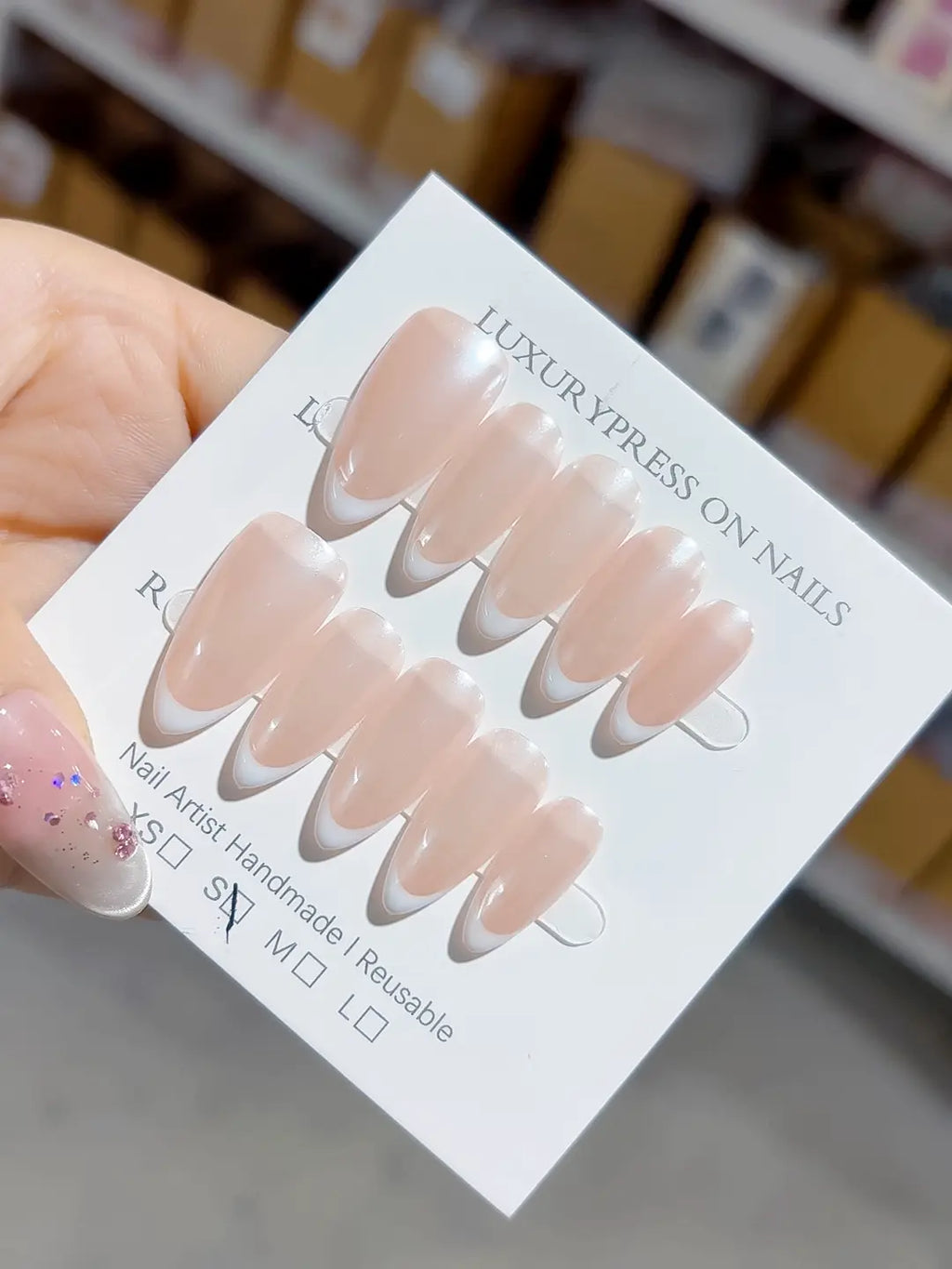 handmade press on nails, medium almond nude french with white tips, angled view