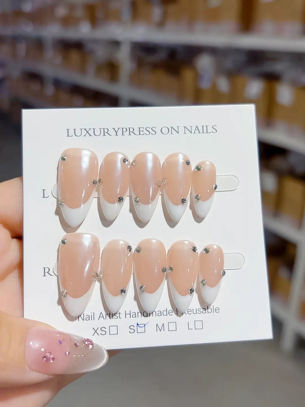 handmade press on nails set, close-up of nude base with rhinestone accents and crisp white french tips